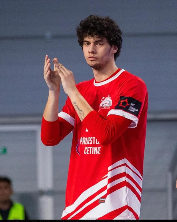 Ein Mann in rot-weißem Shirt klatscht in den Händen vorne, mit einer anderen Person und einer Wand im Hintergrund; Text unten lautet "Copenhagen Futsal Club - Foto 1".