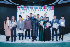 Gruppe von Menschen auf einer Bühne mit Blumensträußen und Urkunden, vor dem Hintergrund 'Youth Solar Awards 2019'