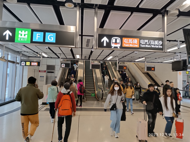 Menschen mit Gepäck durch einen geschlossenen Flughafen gehen, Rolltreppen, Informationsbildschirme und Glaswände im Hintergrund.