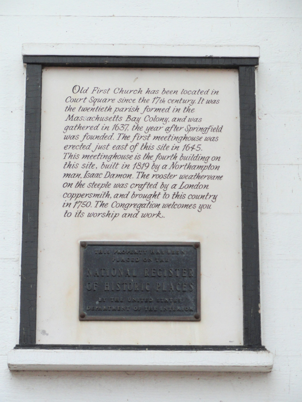 Plaque auf einer Gebäudewand mit der Aufschrift "National Register of Historic Places" in fetter Schrift, auf dunklem Material mit dekorativem Rand montiert.