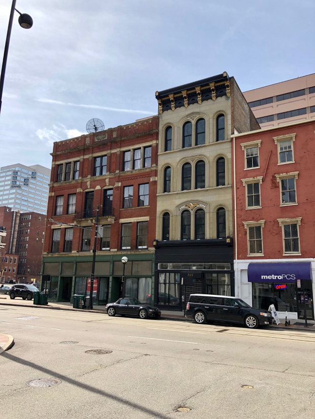 Stadtstraße mit parkenden Autos, Laternen, Mülltonnen und Gebäuden unter einem bewölkten Himmel, mit einem gewerblichen Immobilienangebot an 715 N Main St, Chicago, IL 60611.