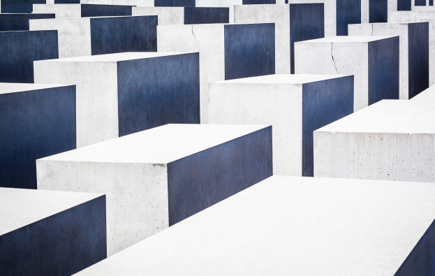 Luftaufnahme des Holocaust-Mahnmals für die ermordeten Juden Europas in Berlin, mit zahlreichen rechteckigen Betonsteinen in einem Gittermuster.