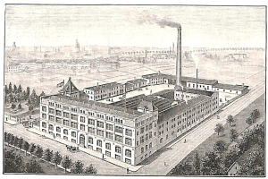 Alte Fabrik mit einem großen zentralen Gebäude umgeben von Bäumen und Text unten.